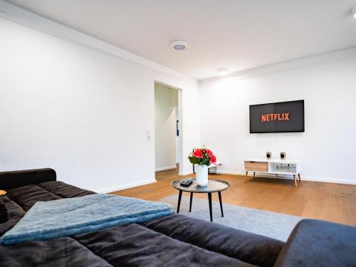 a living room with a couch and a tv on the wall at Whirlpool - zentral - Designloft mit XXL Terrasse in Wiesbaden