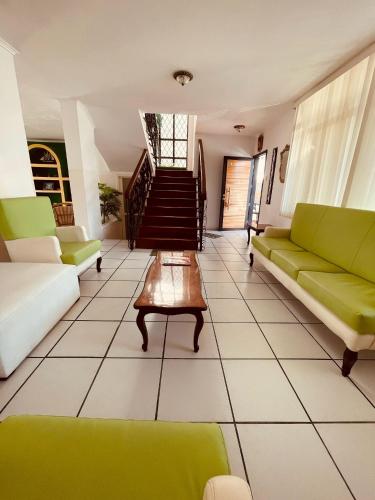 a living room with green couches and a table at Casa en Punta Barandua Playa Privada in Santa Elena