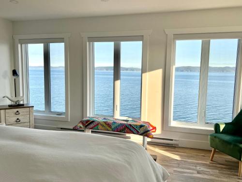 a bedroom with a bed and a view of the water at The View suites and breakfast in Triton, Newfoundland in Pilleyʼs Island