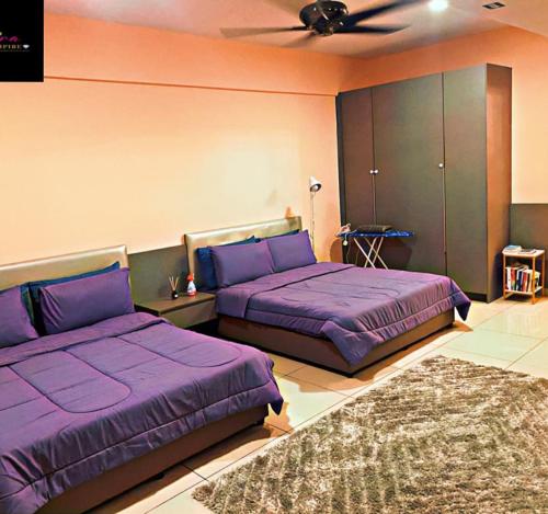 two beds in a room with purple sheets at Fasmira Evo Suite Duplex Homestay Bangi With Pool in Bangi