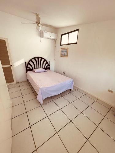 a bedroom with a bed and a tiled floor at Casa en Punta Barandua Playa Privada in Santa Elena