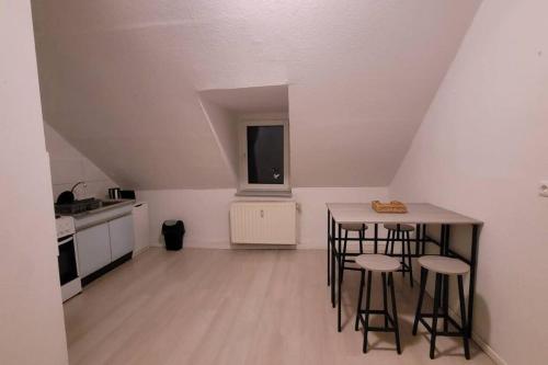 a kitchen with a table and stools in a room at Schöne Apartment im Zentrum Gelsenkirchen in Gelsenkirchen