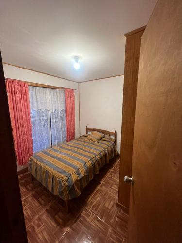 a small bedroom with a bed and a window at cabaña Wenu Mapu queule in Queule