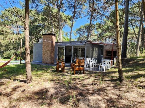 a house with chairs and a fireplace in the woods at Ohana2 Punta Ballena cero nueve siete tres uno ocho ocho nueve cinco in Punta del Este