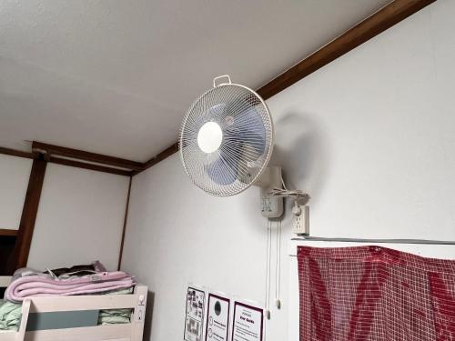 a white fan hanging from a ceiling in a room at Hostel Murasaki in Takayama