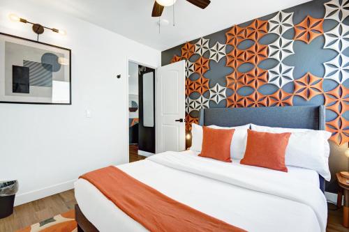 a bedroom with a large bed with orange pillows at IndyOasis: pool*spa*games*BBQ*4BR2BA. Wlk2Festivls in Indio