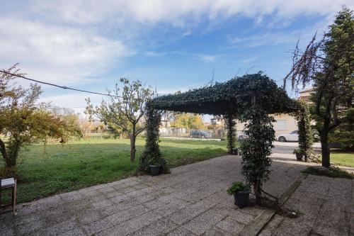 a pergola covered in ivy in a park at Billiard Home in Trikala in Tríkala