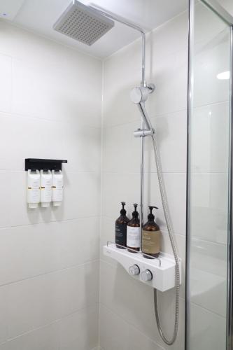 a bathroom with a shower with soap and bottles at Sim On Chae - one room in Yeosu
