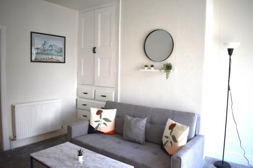 een woonkamer met een grijze bank en een tafel bij Kisobi Home Bedroom 2 in Hull
