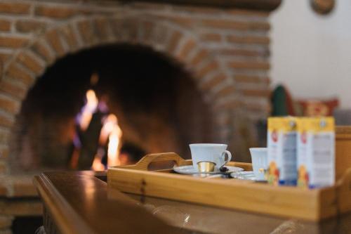 a tray of coffee cups sitting on a table in front of a fireplace at Billiard Home in Trikala in Tríkala