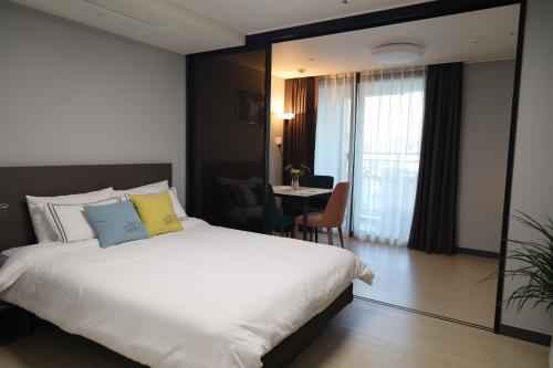 a hotel room with a bed and a table at Sim On Chae - one room in Yeosu