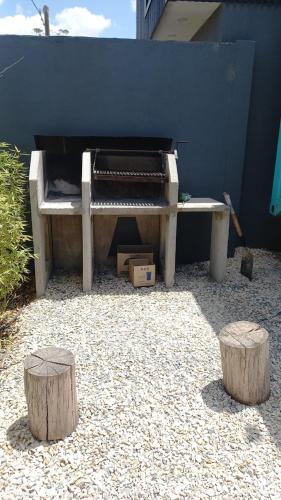 a bench and two logs in front of a wall at Casacubo Necochea in Necochea