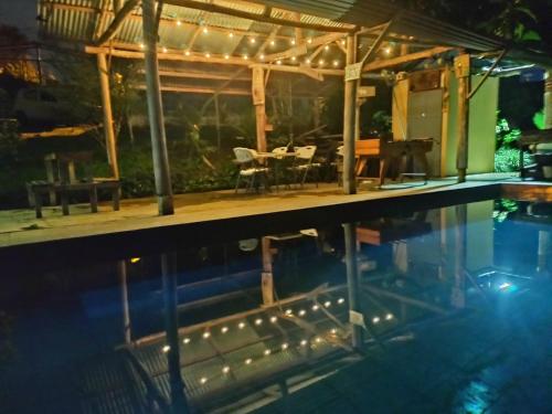 ein Schwimmbad in der Nacht mit Licht an einem Haus in der Unterkunft Cabaña Familiar 7 Colinas in San Vito