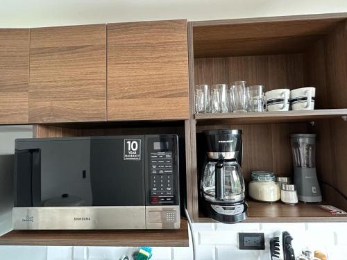 a kitchen with a microwave and a blender on a shelf at EON apartamentos in Guatemala