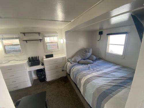 1 dormitorio pequeño con 1 cama y 2 ventanas en Midtown Charm: 1BR Urban Pad en Reno