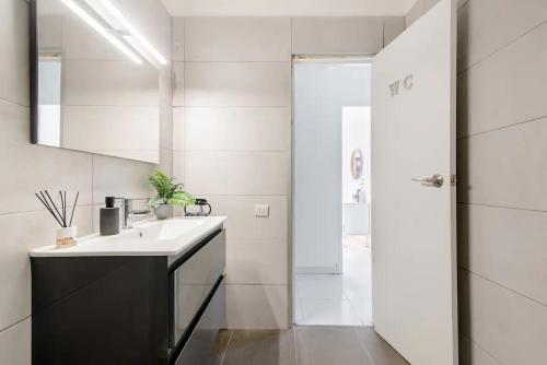 uma casa de banho branca com um lavatório e um chuveiro em SantaRooms em Santa Cruz de Tenerife