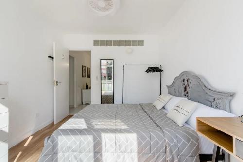 um quarto branco com uma cama grande e lençóis brancos em SantaRooms em Santa Cruz de Tenerife