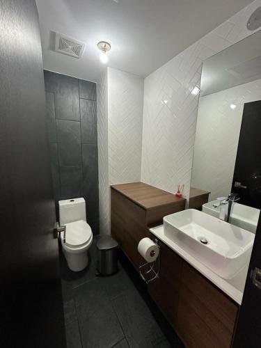 a bathroom with a sink and a toilet and a mirror at EON CITY in Guatemala