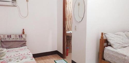 a bedroom with a bed and a mirror on the wall at Calitang Pearl Cottage in Nacpan