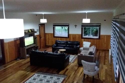 a living room with a couch and a tv at Casa en Villa García, cerca de Melipeuco y Cunco in Cunco