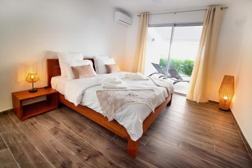 a bedroom with a large bed and a large window at LA PLAGE MARTINIQUE in Schœlcher