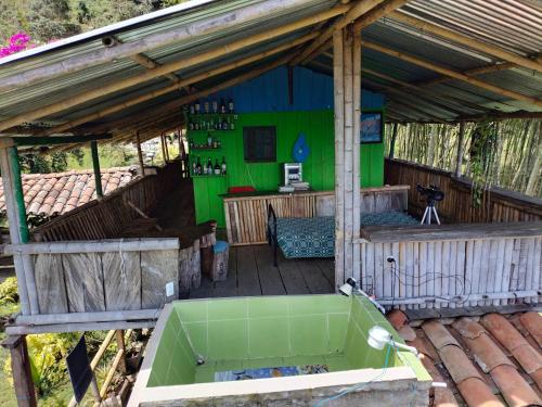 an outdoor hot tub on a deck with a green wall at Sierra de viboral adventures in Medellín