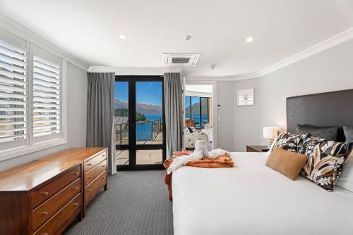 - une chambre avec un grand lit blanc et un balcon dans l'établissement 3-bedroom Penthouse Apartment with Spa - The Beacon 1002, à Queenstown