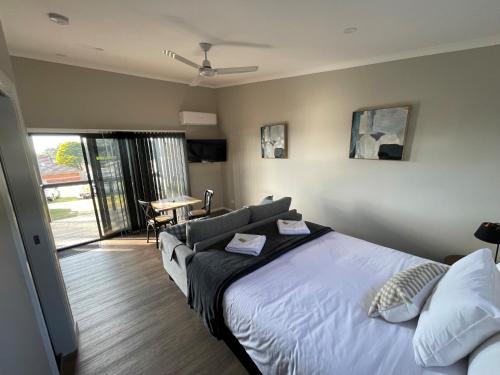 a bedroom with a bed and a living room with a table at Moss Vale Village Park in Moss Vale