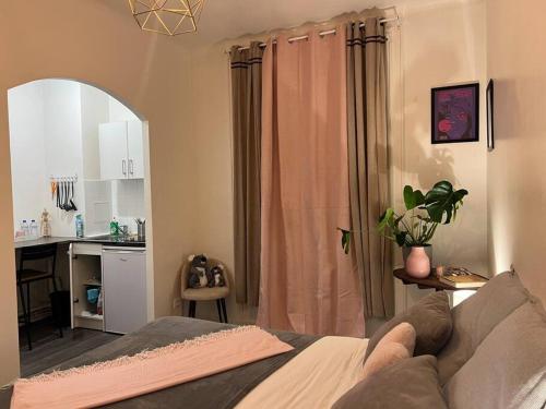 1 dormitorio con 1 cama y cocina con mesa en Cosy studio south of Paris - MP52B, en París