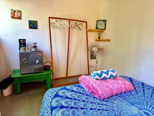 a bedroom with a bed with two pillows on it at Casa Mariposa in Puerto Viejo