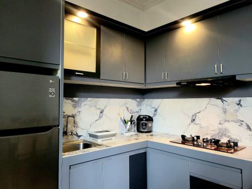 una cocina con encimeras de mármol blanco y negro en MG'S Villa en Batu