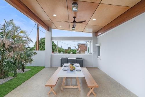 a patio with a table and bench on a patio at The Elements l Water l 4 Stunning Apartments each with Private Outdoor Dining l Walk to the Beach l Pet Family and Event Friendly l Wifi l Netflix l Outdoor Shower l Communal BBQ Pavilion and Lawn Area l in Christies Beach