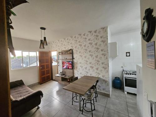 a living room with a table and a kitchen at Apartamento 2 Quartos Bertioga WVM in Bertioga