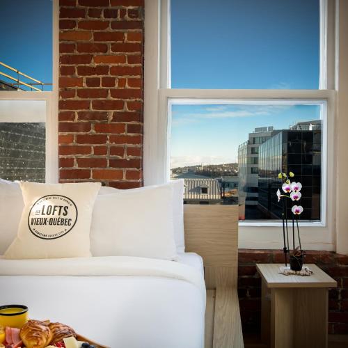 a white couch in a room with a window at Les Lofts de la Barricade - Par les Lofts Vieux-Québec in Quebec City