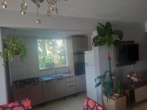 a kitchen with a white refrigerator and a window at Joelma luzia Corrêa in Penha