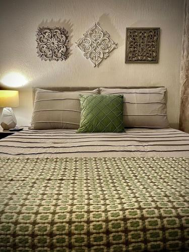 1 cama grande con 2 almohadas verdes en Casa 96, en Guatemala