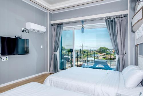 um quarto de hotel com duas camas e uma janela em Mulddeule Shimpang Resort em Jeju
