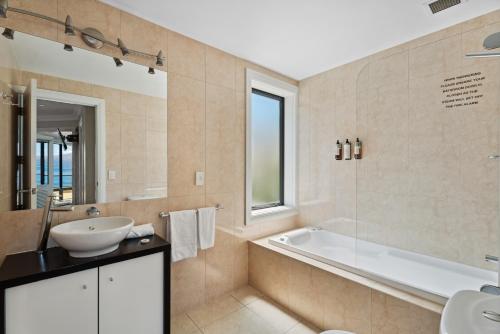 Un baño con bañera, lavabo y bañera. en 2-bedroom Penthouse Apartment with Spa - The Beacon 1004, en Queenstown