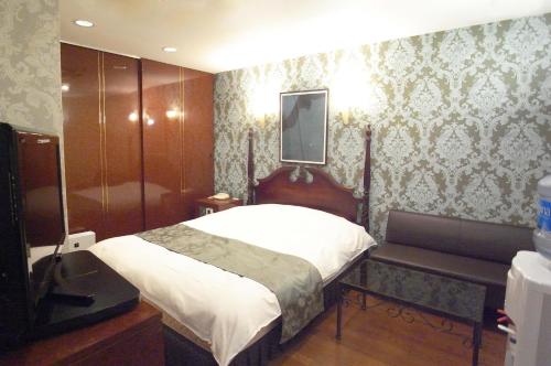 1 dormitorio con 1 cama y ducha. en ホテル タイムレス 明石 男塾ホテルグループ en Akashi