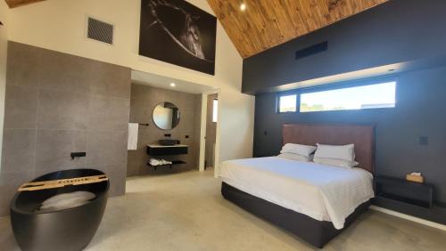 sypialnia z dużym łóżkiem i dużym oknem w obiekcie Chalet Hills w mieście Sampsons Flat
