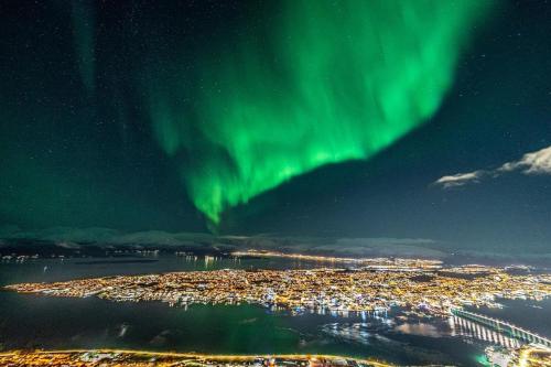 an aerial view of a city under the aurora at Ami Hotel in Tromsø