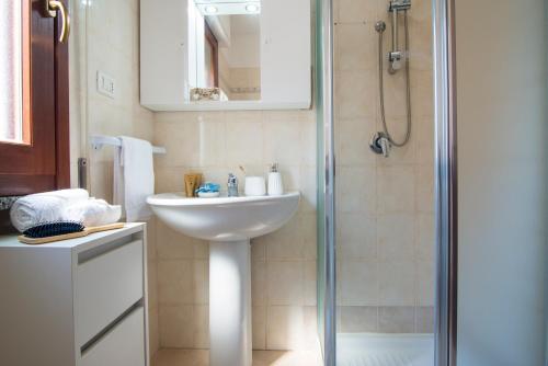 uma casa de banho com um lavatório e um chuveiro em [Oristano centro] Parcheggio privato, Wifi+Netflix em Oristano
