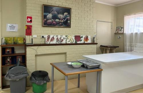 eine Küche mit einer Theke, einem Tisch und einem Kamin in der Unterkunft Broken Hill Tourist Lodge in Broken Hill