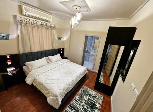 - une chambre avec un lit doté de draps blancs et une fenêtre dans l'établissement The Arabella House - New Cairo, au Caire