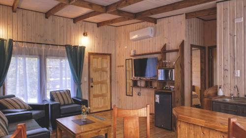 sala de estar con sofá y mesa en Cabaña Los Coihues, en Puerto Montt