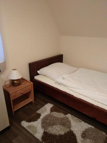 a bedroom with a bed and a table with a lamp at Oaza Huzele in Hużele