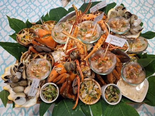 a plate of seafood and other foods on a table at Beach House Lodge in Poum