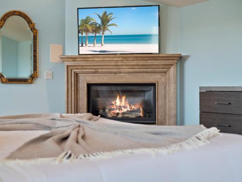 una camera da letto con camino e TV sopra di La Jolla Luxury Estate - Massive Yard, Pool-Spa, Fast WiFi & Outdoor Fireplace a San Diego