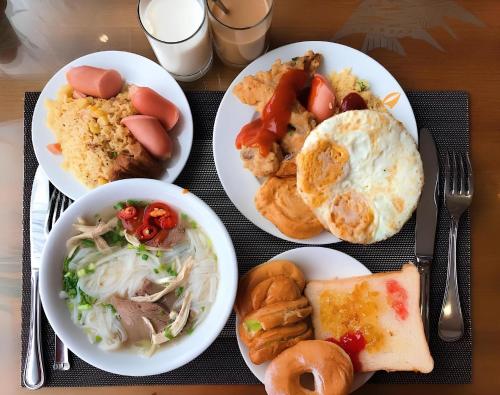 a table with plates of food on a table at Calet Hotel in Cat Ba