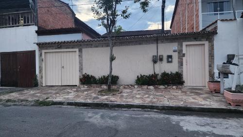 a house with two garage doors on a street at Casa aconchegante com piscina in Paraty